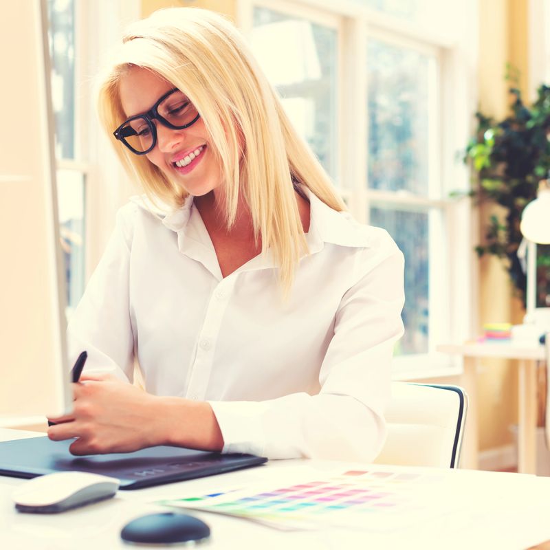 Graphic designer using her graphic tablet in an office