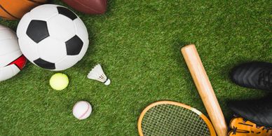 Various sports equipment arranged on green grass.