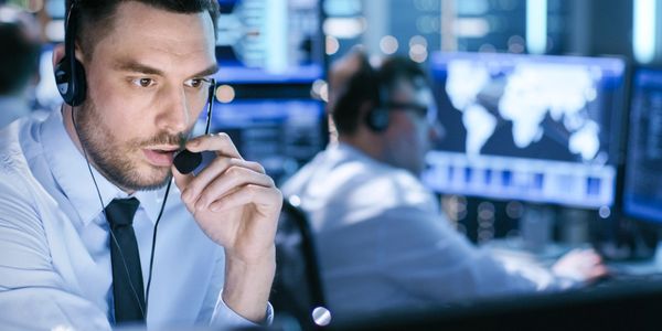Agent de surveillance 24/7 supervisant des alertes depuis un centre de contrôle.