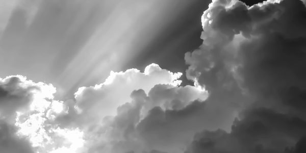 Black and white photo of sun rays through clouds.
