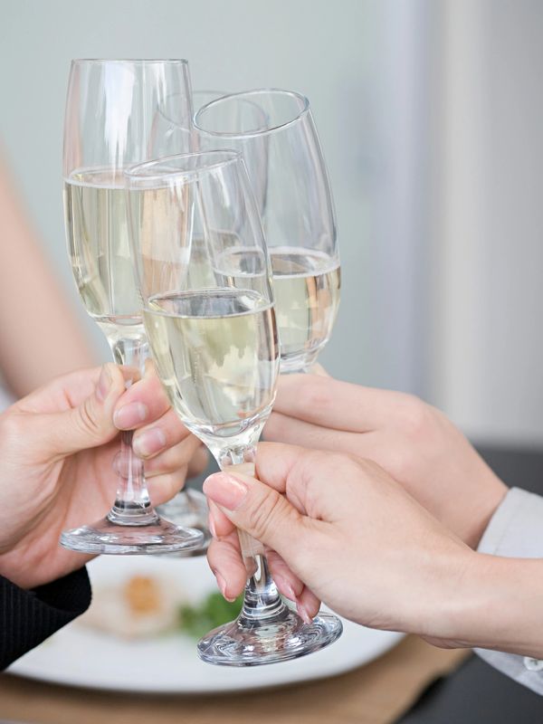 Three people toasting with champagne glasses at a gathering.