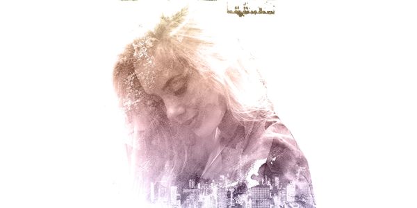Double exposure of a woman and a cityscape blending together.
