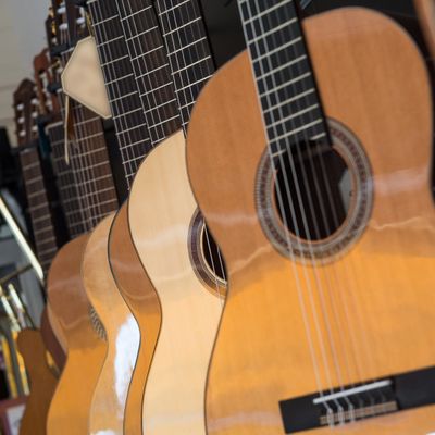 Close-up of several acoustic guitars lined up in a row.