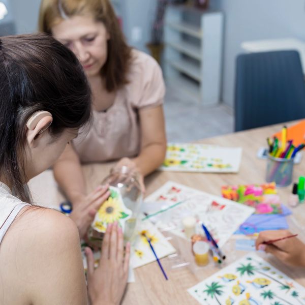 People painting and decorating glass jars.