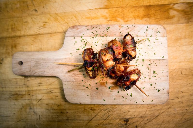 Jumbo dates wrapped in thick cut bacon with parmesan cheese added and sauted.