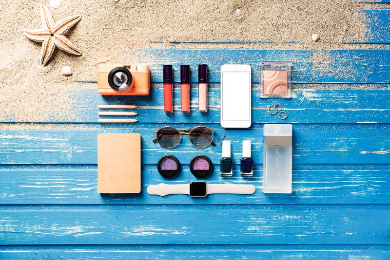 Flat lay shot of summer accessories on blue wooden beach platform