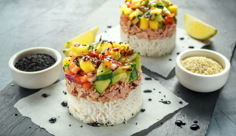 Tuna sushi stacks with mango, cucumber, tomatoes salsa served with balsamic vinegar, nigela ans sesame seeds.