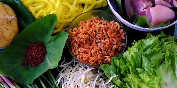 Fresh ingredients including dried shrimp, vegetables, and herbs for cooking.