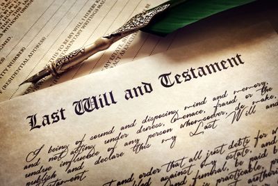 A vintage quill pen resting on a Last Will and Testament document.