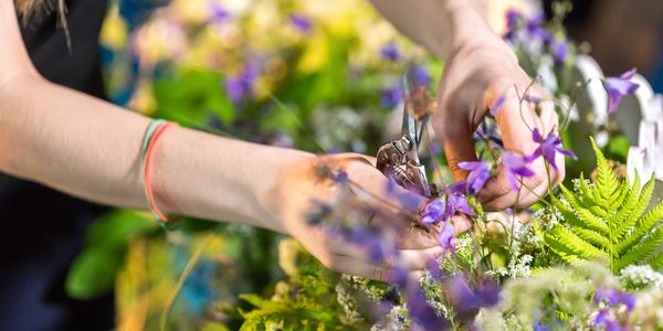 a woman making a bouquet of Purple and white combination flowers