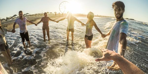 a group of people enjoying themselves in the water at a beach