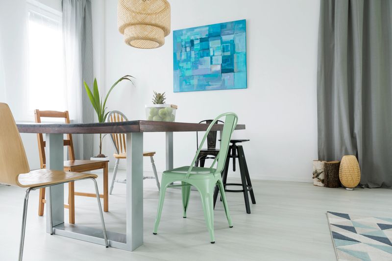 Dining room with communal table, chairs, lamp and window curtain