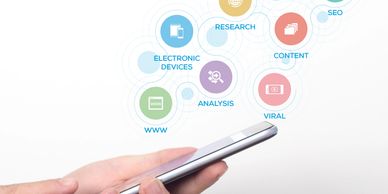 Hand holding smartphone with digital marketing icons and labels floating above.