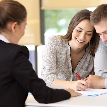 Couple signing documents with a professional woman.