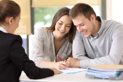 Couple signing documents with a professional.
