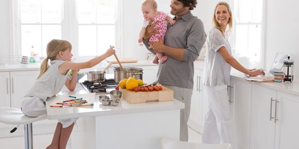 Family cooking together in a bright kitchen.