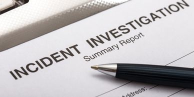 Pen resting on an incident investigation summary report.