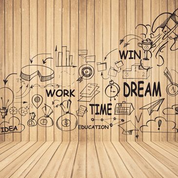 Motivational business concepts sketched on a wooden wall.