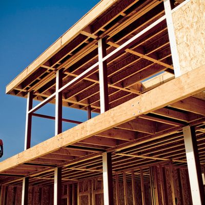 Wooden framework of a building under construction against a clear sky.