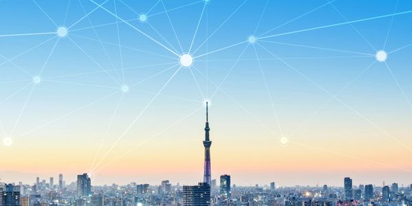 Una gran ciudad con una torre de teleco futurista que se conecta a una red digital en el cielo.