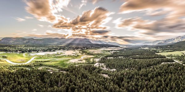 A picturesque landscape featuring rolling hills, a clear blue sky, and vibrant greenery.