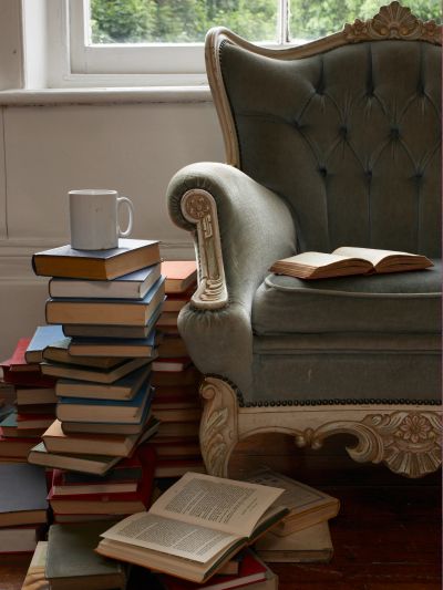 Cozy reading nook with books and a cup.