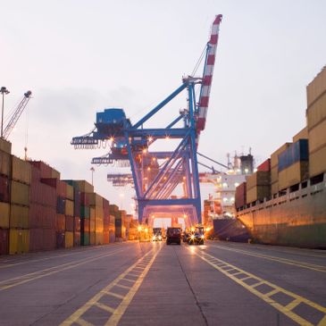 Container crane at a shipping port during dusk.