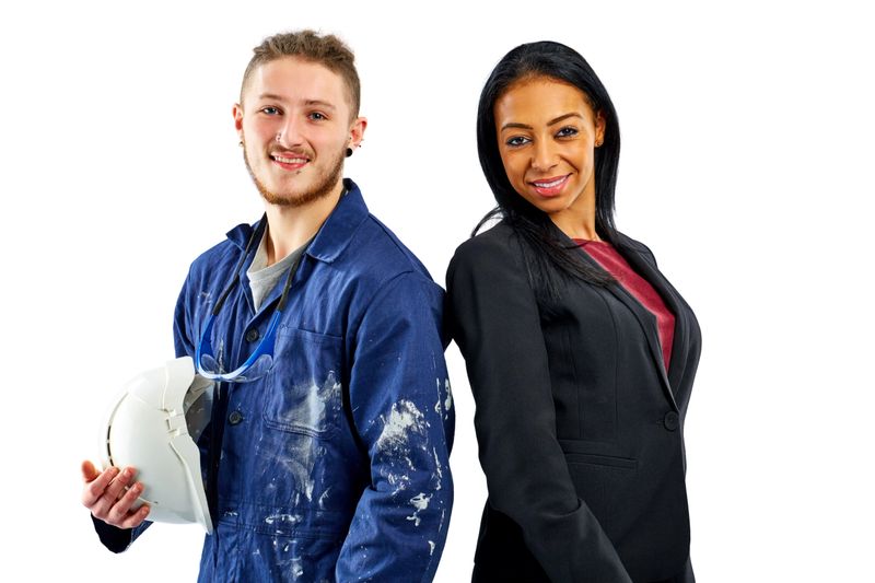 Portrait of hispanic young businesswoman with worker looking at camera on white background