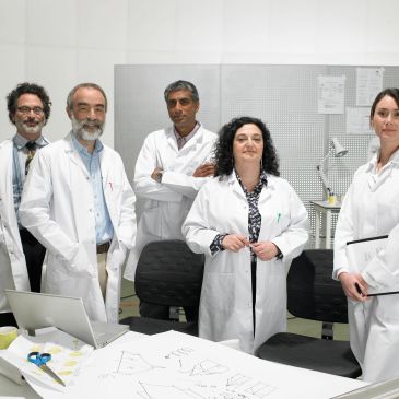 Equipo de científicos en laboratorio con batas blancas.