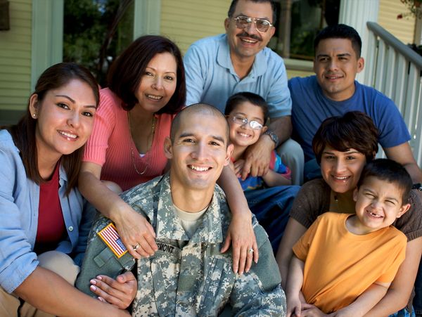 Family gathered around a smiling soldier.