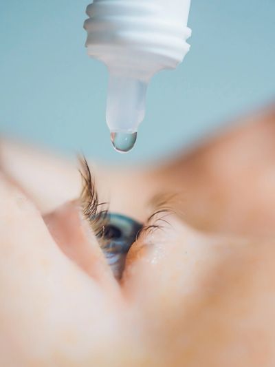 Close-up of an eye with eye drops about to be applied.
