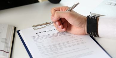 Person signing an employment contract.