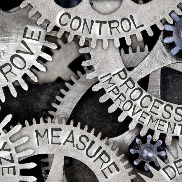 Interlocking metal gears labeled with process improvement terms.