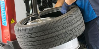 A mechanic is changing a car tire using a tire mounting machine.