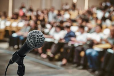 Microphone focus with blurred audience in background.