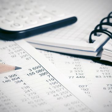 Calculator, pencil, and financial documents on a desk.