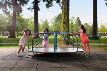 Children having fun on sunny shaded playground.
