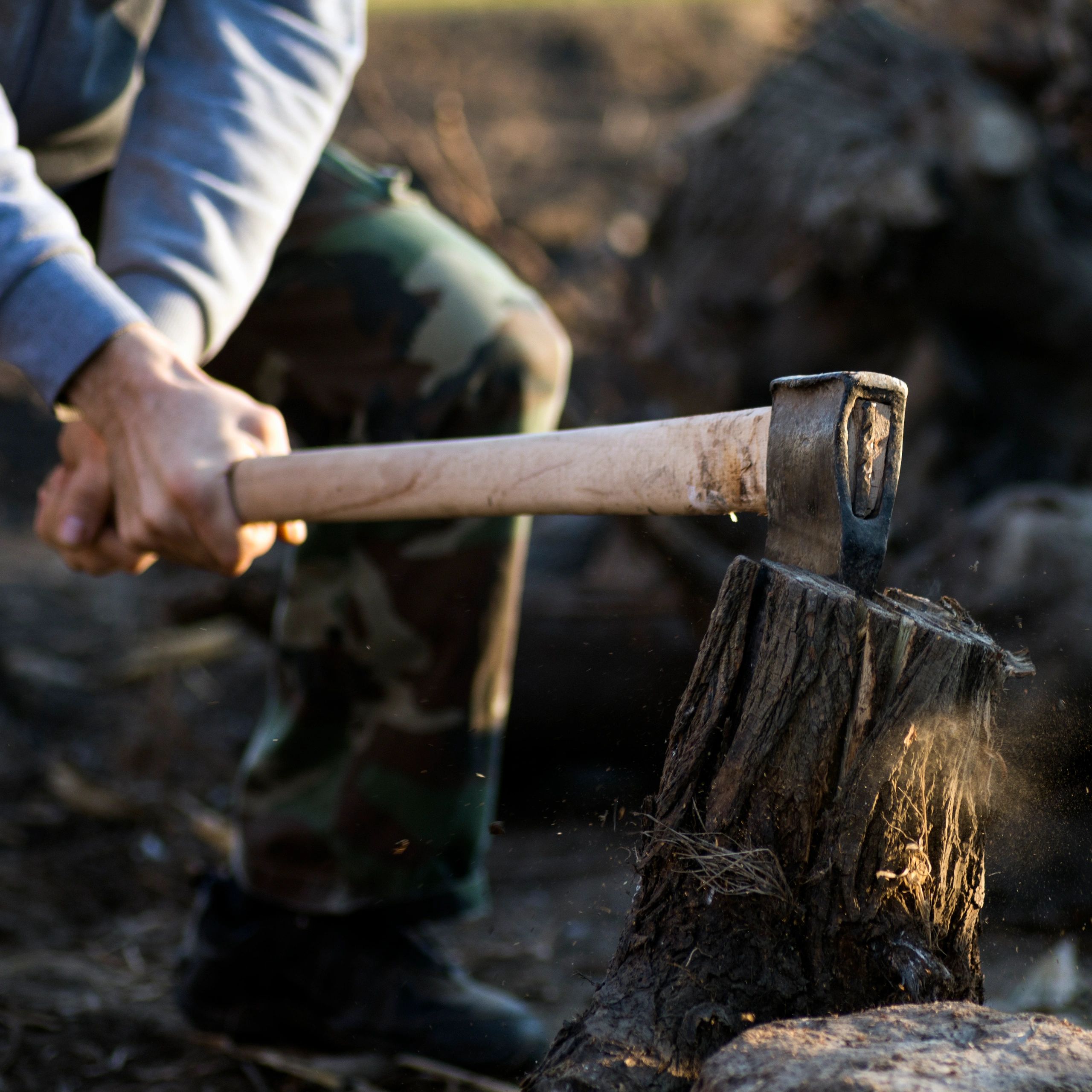 Close-up of a person chopping wood with an axe.