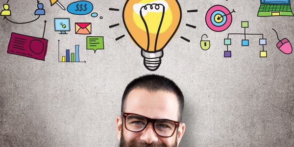 Man with glasses and business icons above his head symbolizing ideas.
