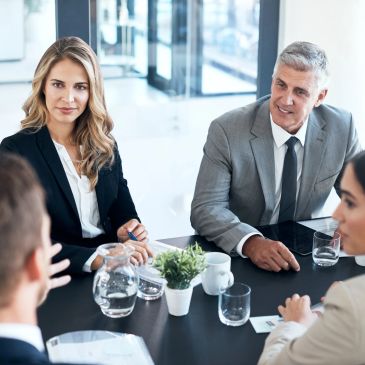 Two women in a professional meeting discussing documents.