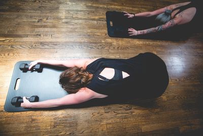 Two women stretching on mats.