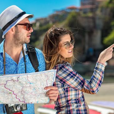 Couple sightseeing with map and camera.