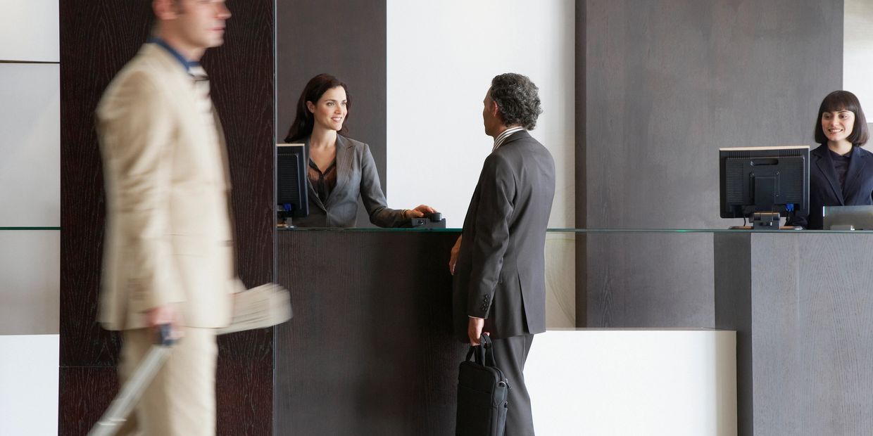 Businessman checking in at a modern hotel reception desk.