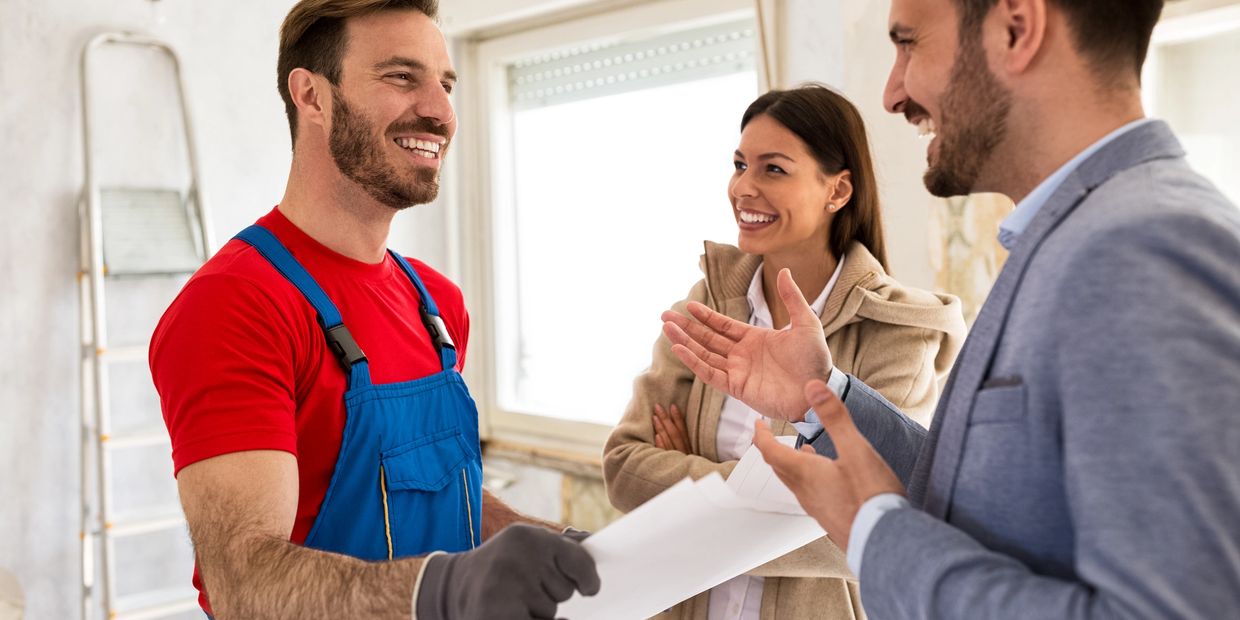 Home renovation discussion between contractor and couple inside a house.