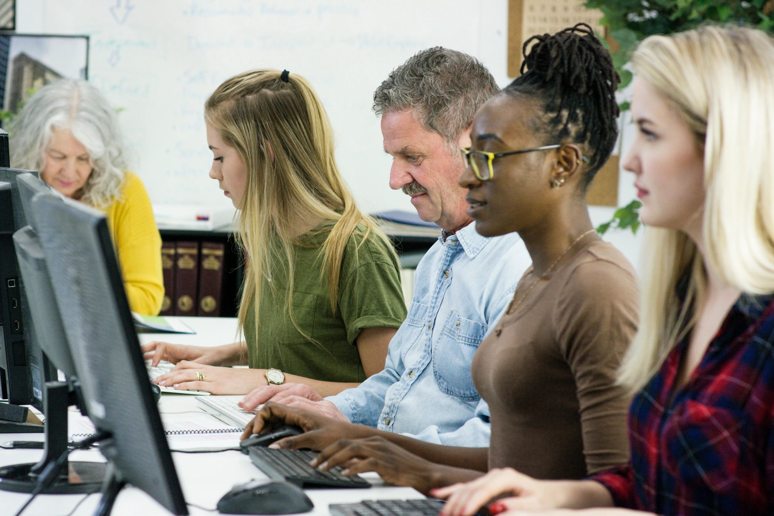 A diverse group working on computers in an office.