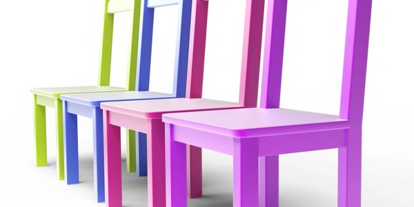 Colorful wooden chairs in a row on a white background.