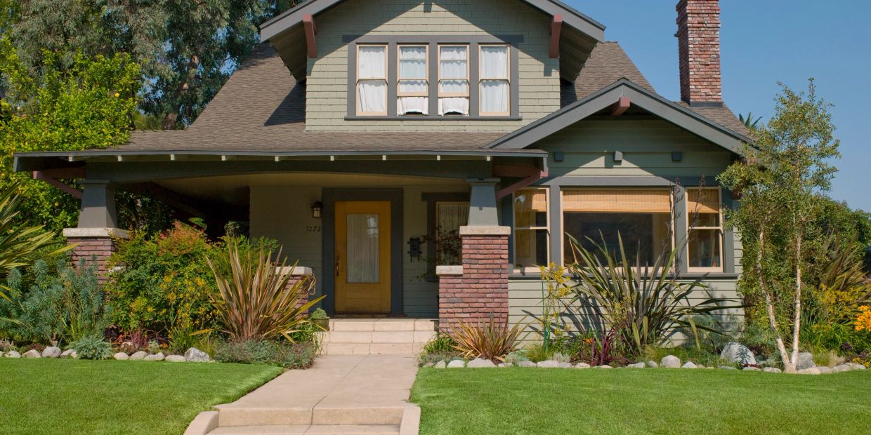 Cozy classic house with a green lawn and plants.