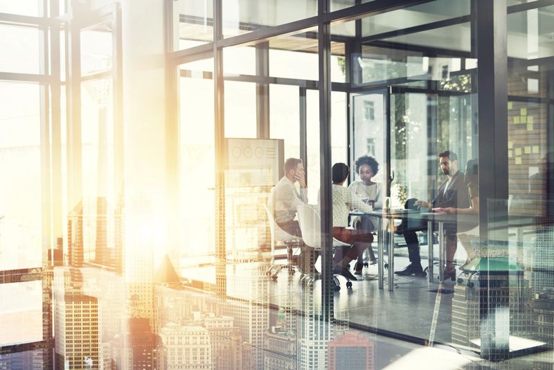 Multiple exposure shot of a businesspeople having a meeting superimposed over a cityscape