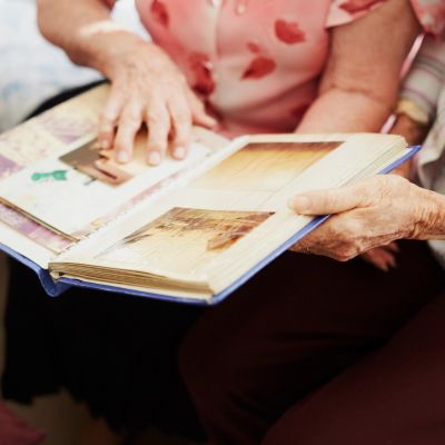 Elderly two women looking at photo album.