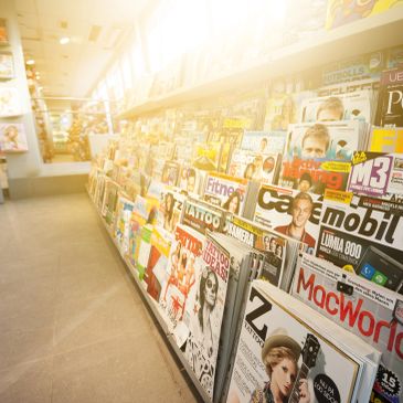 Sunlit magazine stand with various titles.